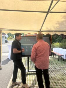 Gespräch am Präsentationsbildschirm im Festzelt der arados Wiesn 2026
