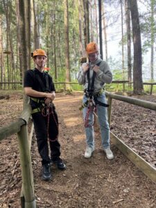 Zwei Azubis mit Klettergurt und Helm im Hochseilgarten Hirschau