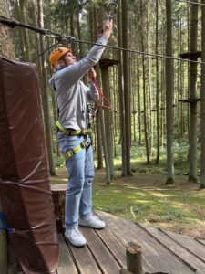 Azubi sichert sich am Seil im Hochseilgarten Hirschau